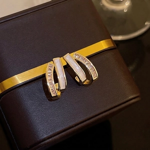 Elegant ivory white and gold earrings with cubic zirconia on leather jewelry box
