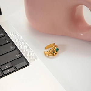 Detail shot of vintage malachite gold ring on desk with multilayer hollow design