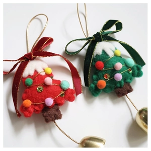 Detail of wool felt Christmas tree ornaments with velvet bows and golden bells