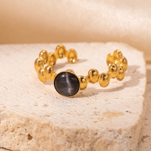 Detail of adjustable 18K gold plated ring with textured band and cat eye stone on stone