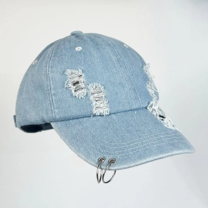 Hellblaue verwaschene Jeans-Baseballkappe mit Metallringen und stylischen Rissen