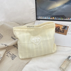 Detail of soft cream fabric makeup bag with lace heart and cute bow decoration