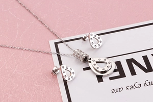 Close-up of silver teardrop necklace and earrings set with sparkling crystal pavé