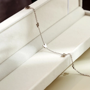 Macro view of a rose gold chain featuring delicate hollow butterfly charms in a jewelry box