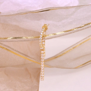 Close-up of elegant gold tassel earrings with zircon crystals on a silk ribbon