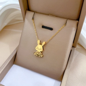 Minimalist gold-plated titanium steel rabbit pendant necklace displayed in a beige jewelry box