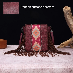 Detail of vintage bohemian crossbody bag with long fringes and leather floral embossing