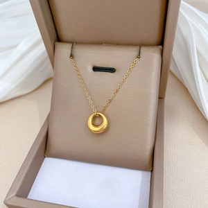 Minimalist gold titanium steel necklace with circular pendant inside a luxury gift box