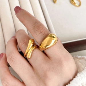 Detailed view of minimalist curved gold ring and twist design on jewelry box