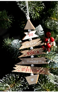 Detail of wooden Christmas tree ornament with Merry Christmas text and pine needles