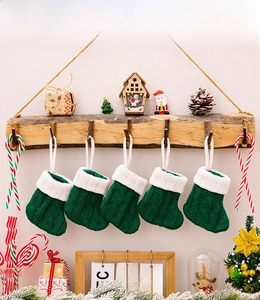 Detail of five green cable-knit mini Christmas stockings with white faux fur cuffs