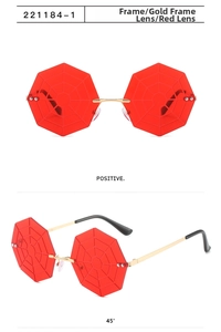 Detail view of red octagonal lenses with 3D spider web texture and gold metal frame