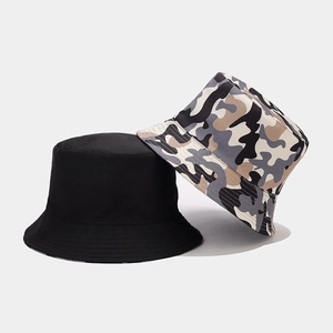 Detail of reversible camouflage and solid black bucket hat with reinforced stitching