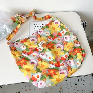 Detail shot of vibrant oil painting flower patterns on a large canvas tote bag