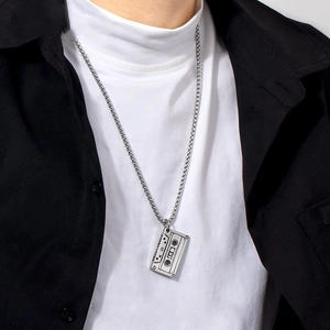 Retro silver cassette tape pendant necklace with sleek metal chain on a male fashion model