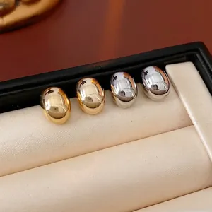 Elegant gold and silver pebble stud earrings set in a minimalist mirror-polished finish