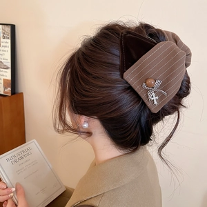 Haarklammer aus braunem Stoff und Samt am Modell für eine elegante Retro-Frisur