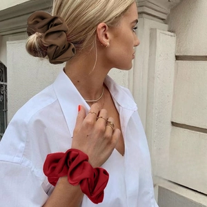 Elastic satin oversized scrunchies in red and brown colors worn on hair and wrist