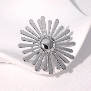 Detailed close-up of a silver sunflower-shaped stainless steel ring on a white surface