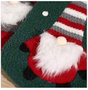 Detailed macro shot of a knitted Christmas stocking featuring a plush Santa gnome design