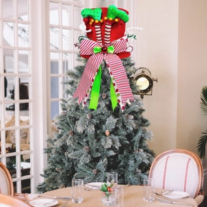 Christmas tree topper featuring elf legs and red striped bow on a decorated festive tree