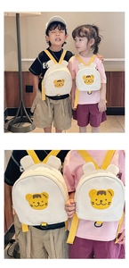 Close-up of white canvas toddler backpack with yellow straps and cute tiger embroidery