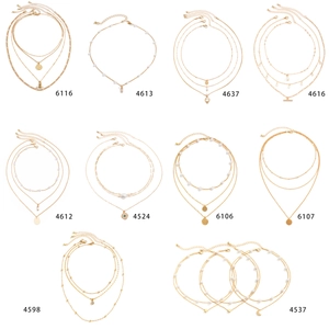 Set of ten gold necklaces with pearls, heart, moon, and water drop pendants on white background