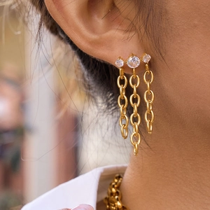 Boucles d'oreilles pampilles en acier doré 18K avec trois zircons portées par mannequin