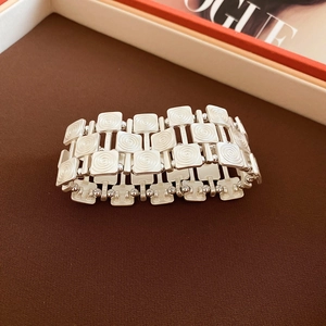 Macro view of vintage silver elastic bracelet with textured square metallic links