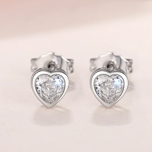 Macro view of heart-shaped zircon earrings with sterling silver four-prong setting