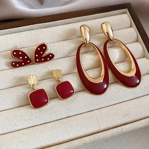 Detail of vintage red enamel heart and pearl earring set in a velvet jewelry box