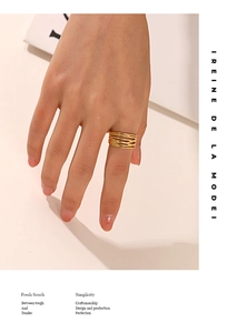 Close-up of a layered golden intertwining ring featuring 18K gold-plated metal texture