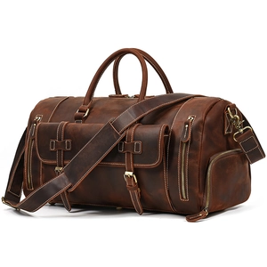 Detail of vintage crazy horse leather travel bag with adjustable shoulder strap and brass hardware