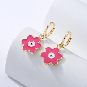 Gold-plated irregular flower earrings with pink enamel and eye detail on white pedestals