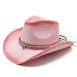 Detail eines rosa Strohcowboyhuts mit böhmischem Webband und natürlichem Muschelbesatz