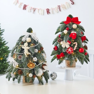 Mini tabletop flocked Christmas cedar tree with festive ornaments and merry banners
