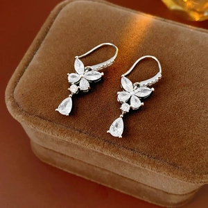 Détails de boucles d'oreilles papillon en argent avec zircons sur boîte en velours brun