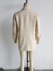 Detail view of the back tailoring and loose fit cut of this beige longline blazer coat