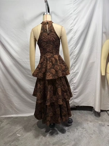 Détail de l'ourlet à volants étagés sur une robe dos nu en jacquard marron foncé