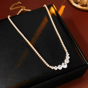 Close-up of gold zircon necklace with gradient round crystals on leather gift box