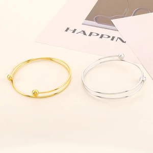 Detail shot of minimalist double-layered steel ball open cuff bracelets in gold and silver