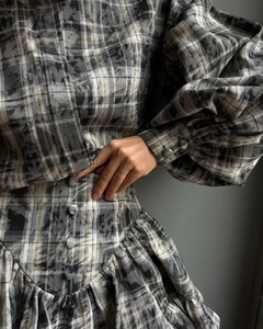 Detail of plaid dress showing bubble sleeves and textured fabric with matching buttons