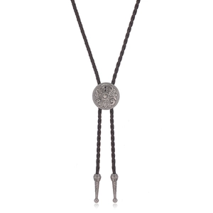 Detail of dark brown braided leather cord and antique silver western bolo tie pendant