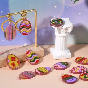 Detailed view of handmade Easter egg resin pendants with golden hooks on decorative stands