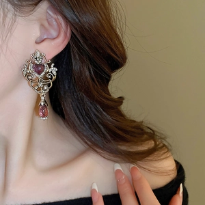 Detail of vintage heart and waterdrop earrings with crystals on female model