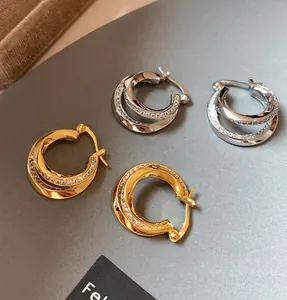 Detailed macro view of double-layer geometric hoop earrings in gold and silver finish
