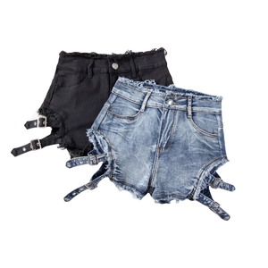 Detalle de pantalones cortos de mezclilla rotos con hebillas laterales y bordes deshilachados