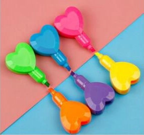 Detail of six heart-shaped highlighters in vibrant colors on a dual-tone background