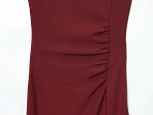 Dettaglio delle pieghe laterali arricciate su un abito smanicato bordeaux casual