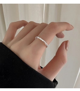 Detailed view of silver square geometric beads ring on woman's index finger